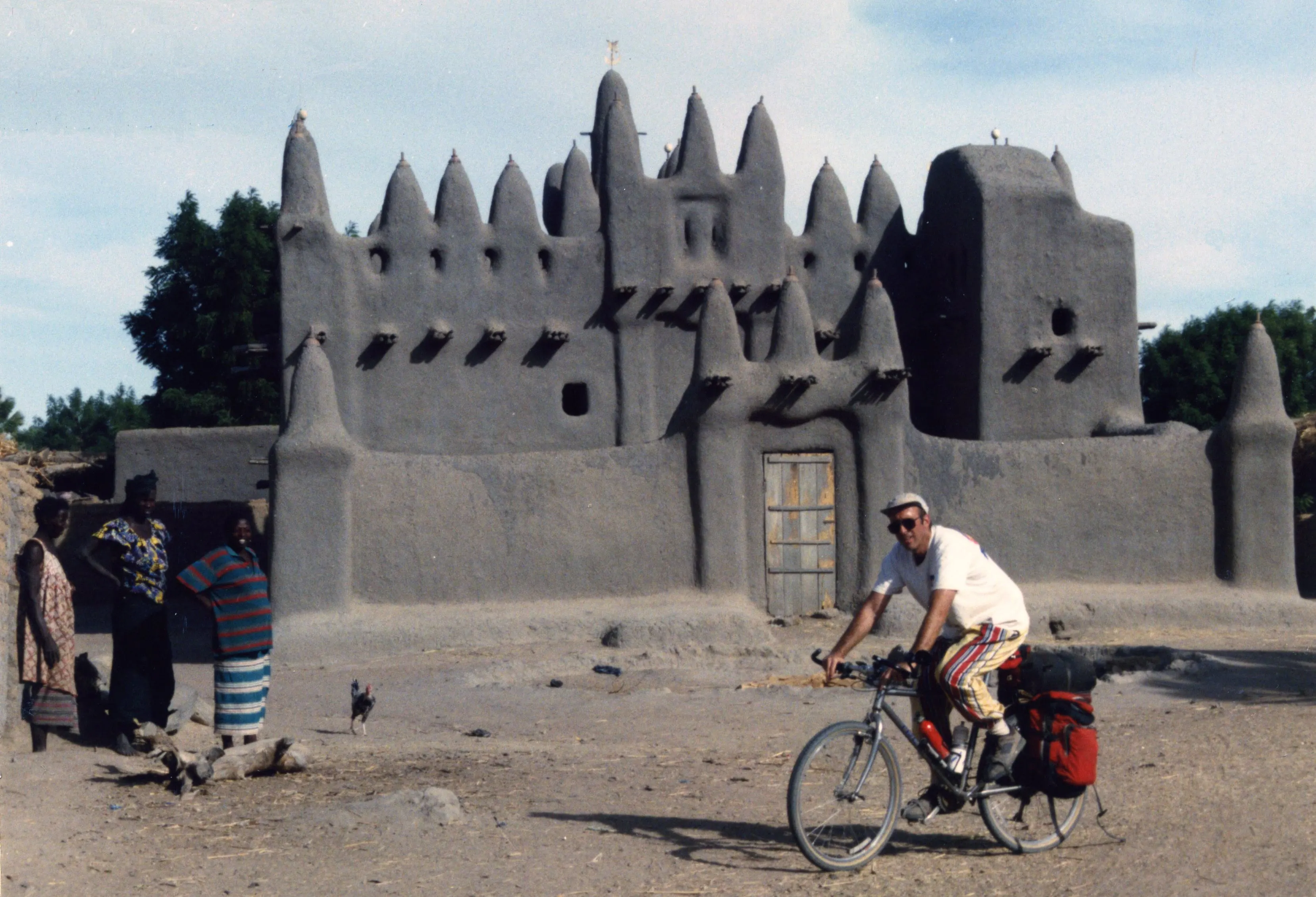 John cycling past a mud brick mosque in Mali in 1996.