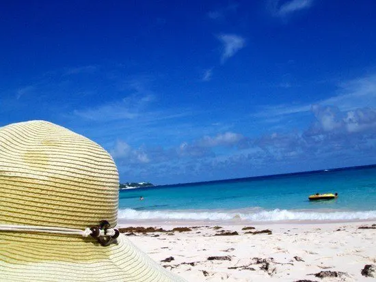 Lindsey at the beach with sun hat on. She writes: "You can get sunburned very easily here so wearing sunscreen and a sunhat is very important here. Learned this the hard way!"