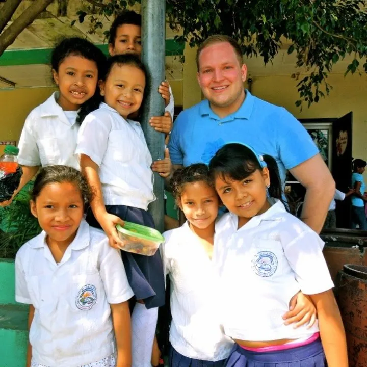 Matt in Honduras, taking a break from painting to spend time with some students.