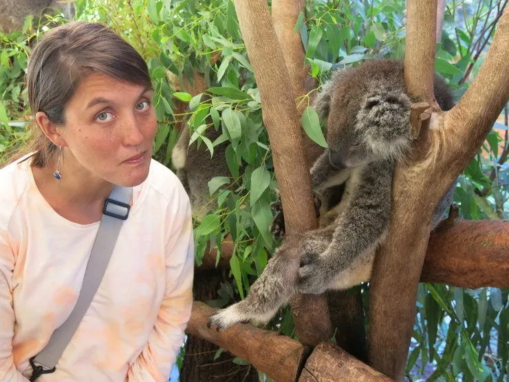 Tasha with a koala in Australia with the look of someone who is disappointed the koalas aren&rsquo;t awake.