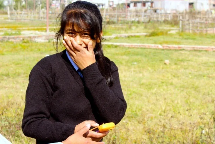 Kopila laughs as she reviews footage from her camera. 