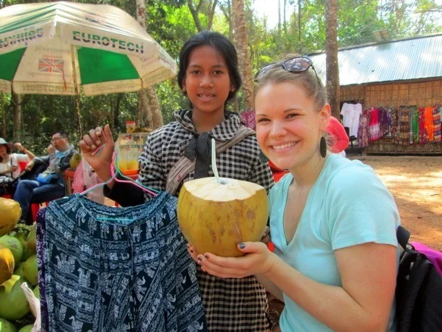 Casey drinking a coconut in Cambodia.