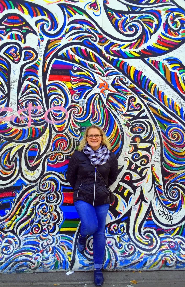 By a beautiful mural in Berlin, Germany.