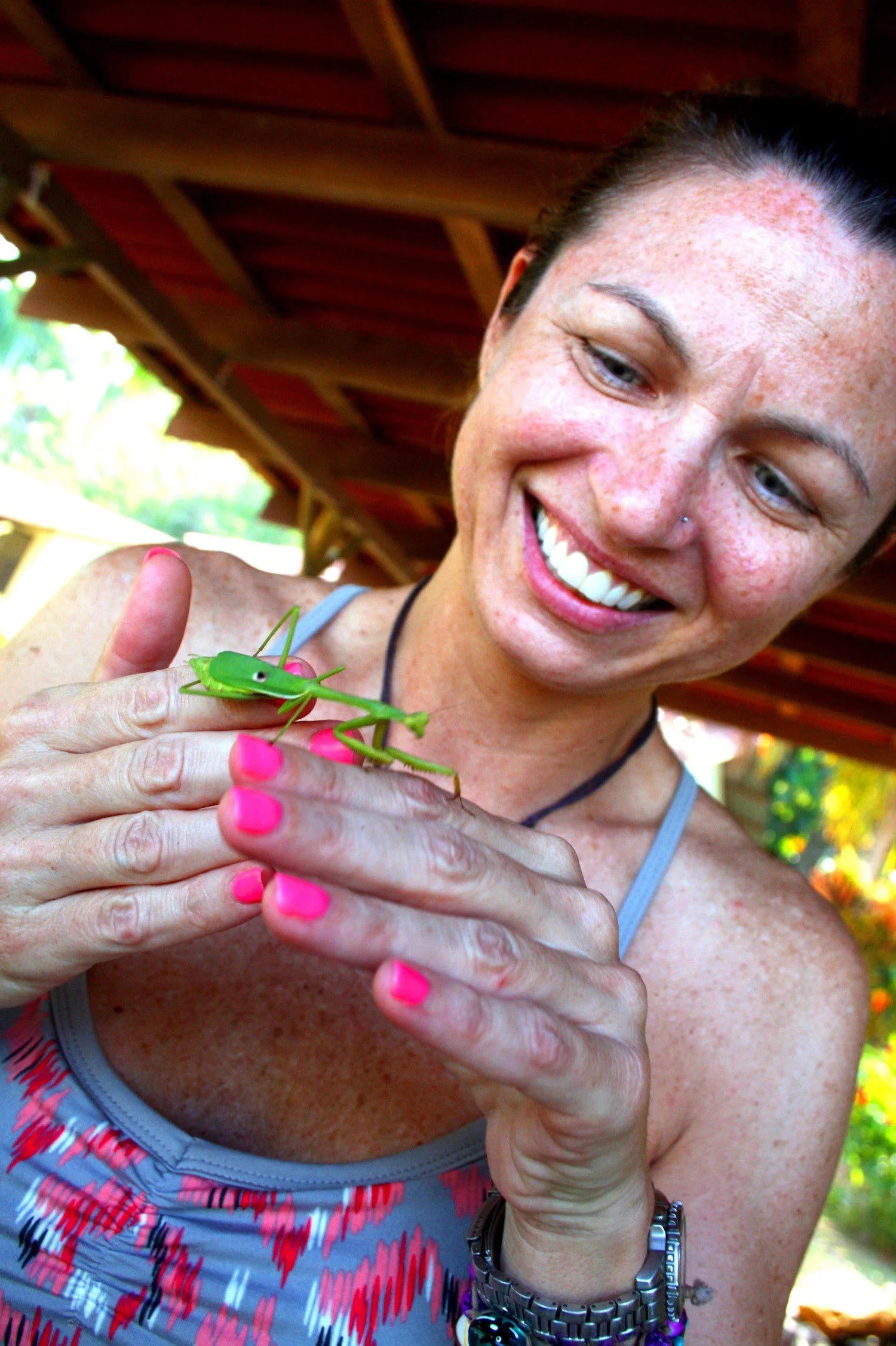 A teacher on the fellowship, examining a praying mantis.