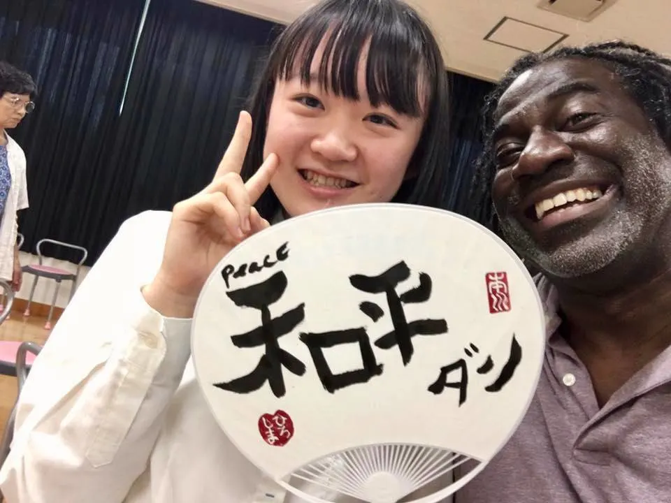 Dunn with a student in Japan, after she taught him to write his name in Japanese.