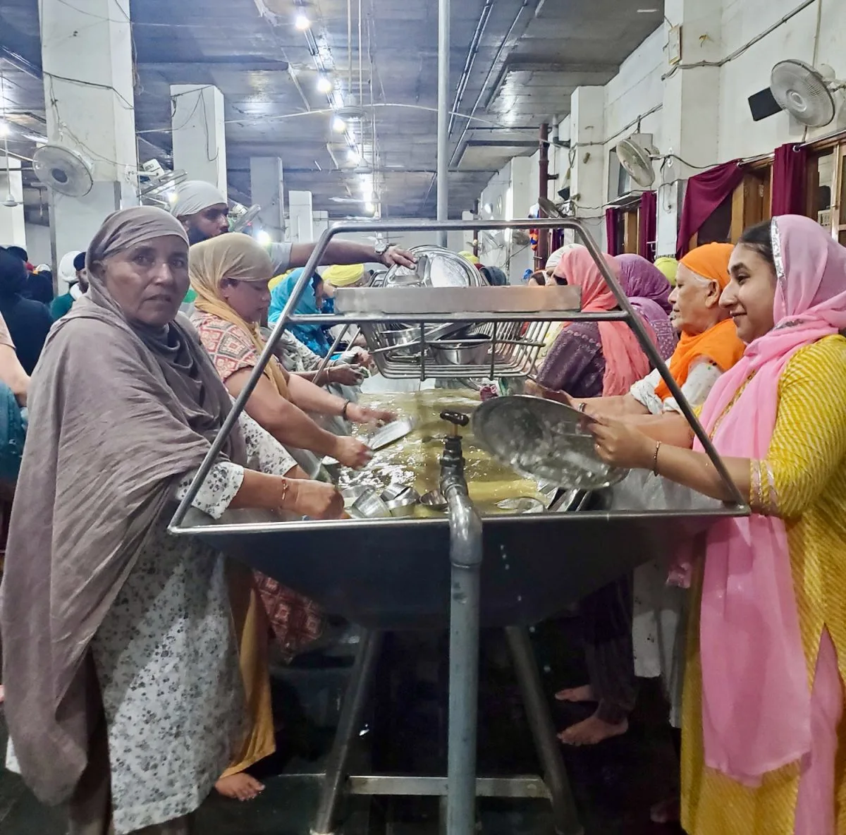Volunteers cleaning dishes from langar at the Golden Temple.
