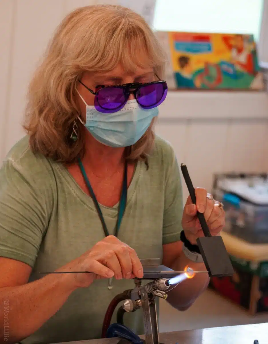 An instructor demonstrating with hot glass.